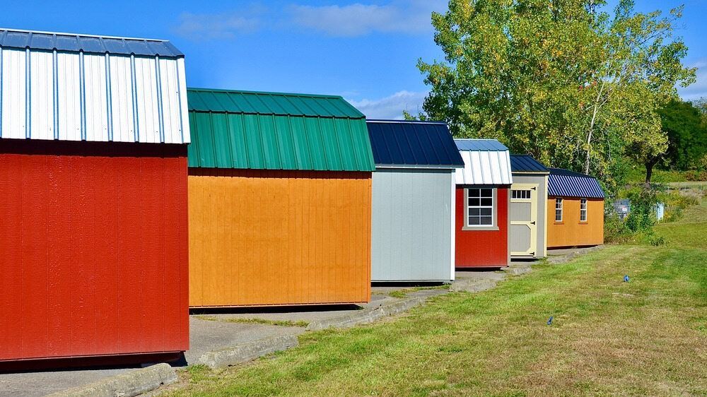 Row of Colourful Sheds Are Lined Up in a Grassy Field — Painter In Sunshine Coast, QLD