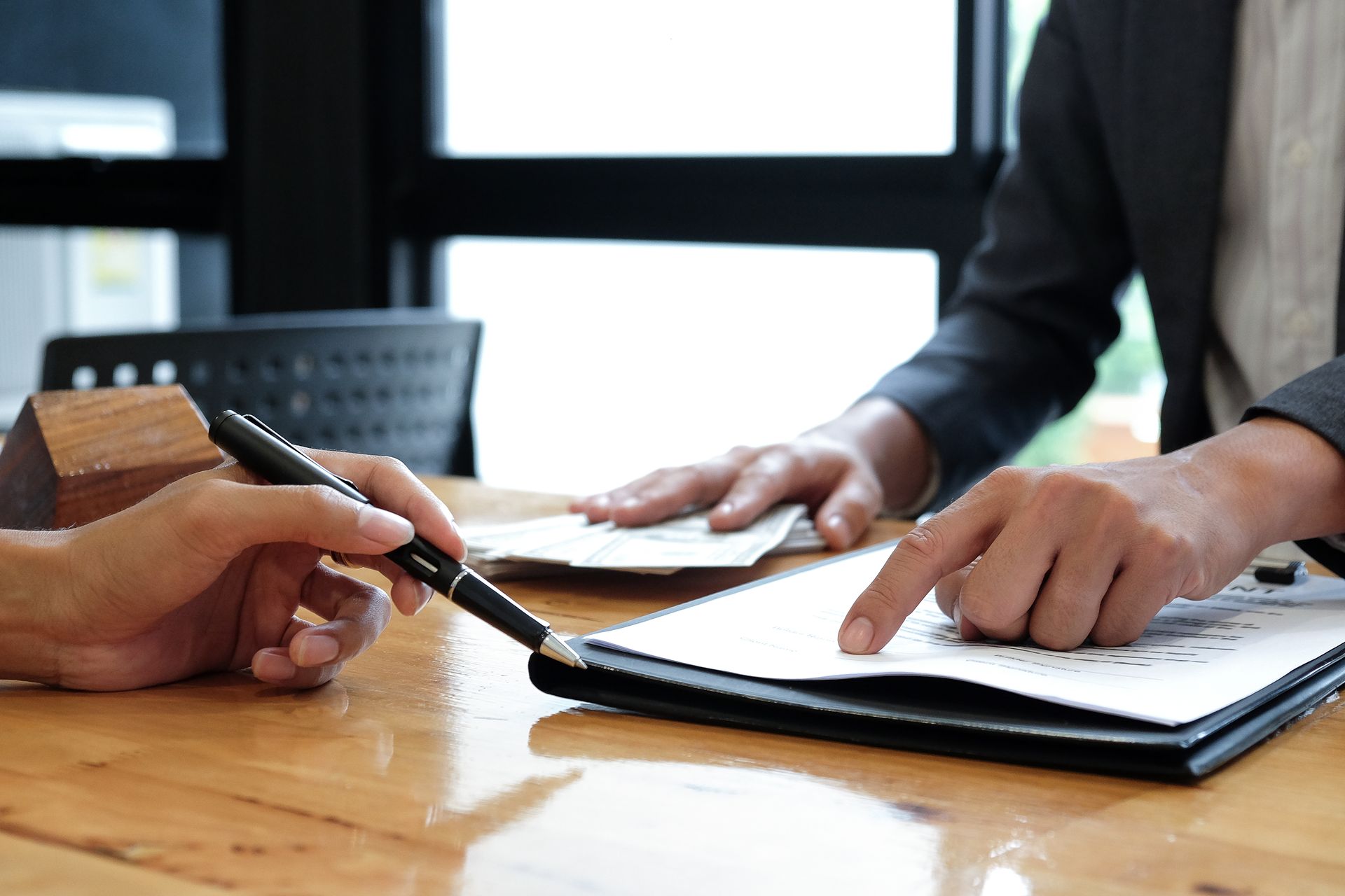 Two people are sitting at a table looking at a piece of paper.