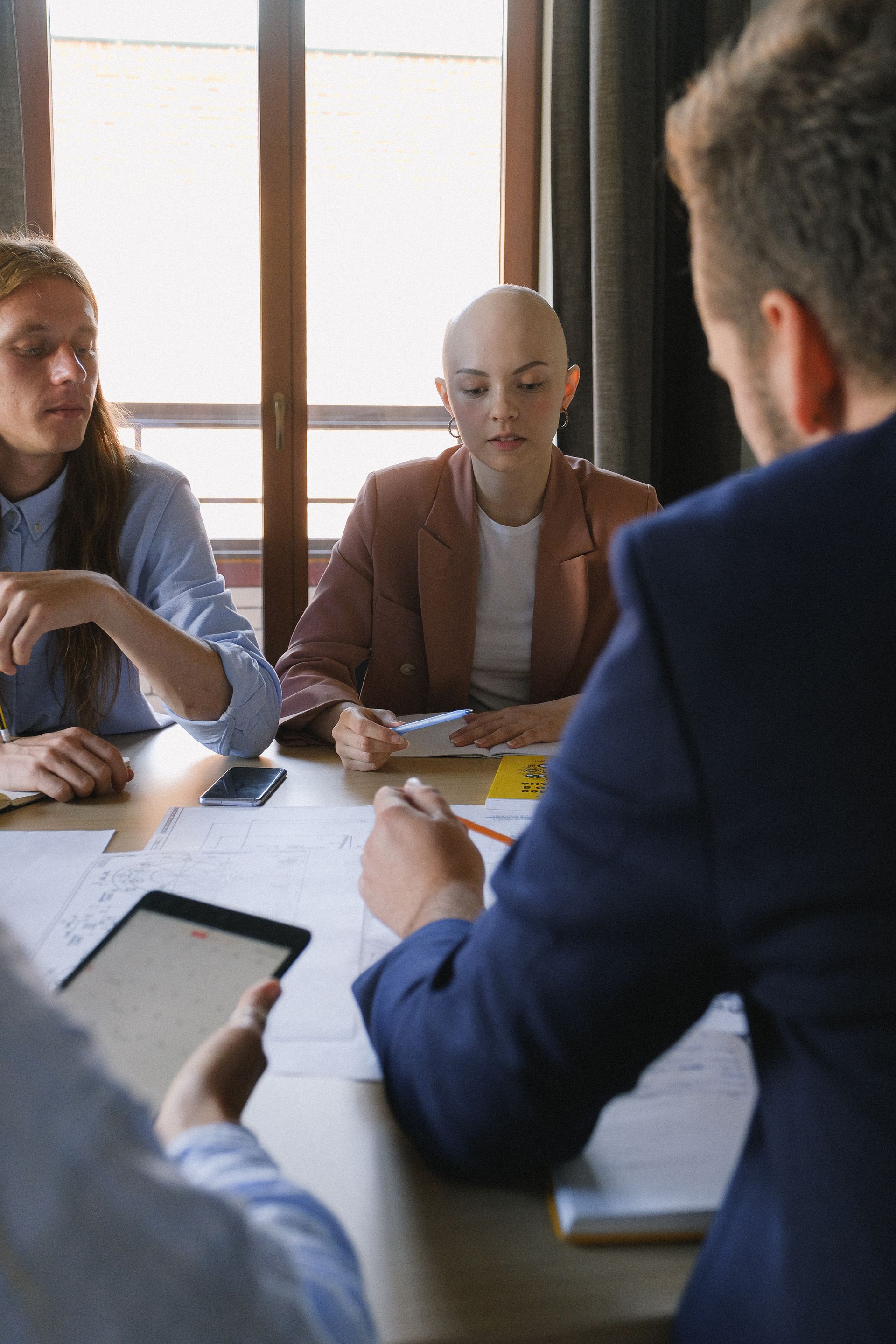 A group of people are sitting around a table having a meeting.