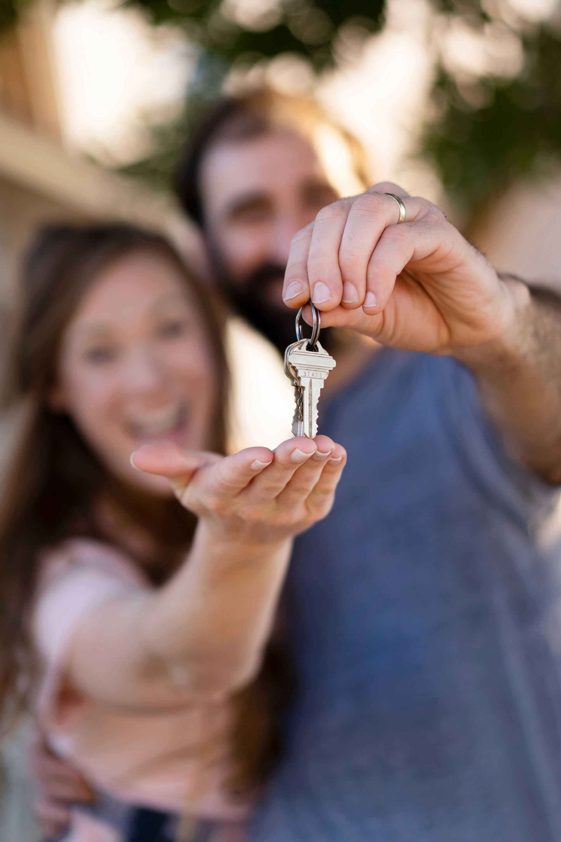 A man is holding a key in front of a woman.