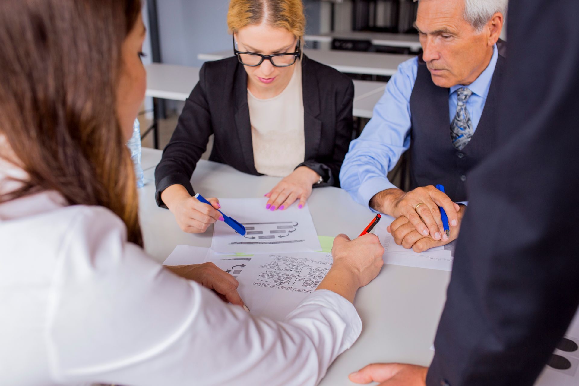 A group of people are sitting around a table looking at papers.