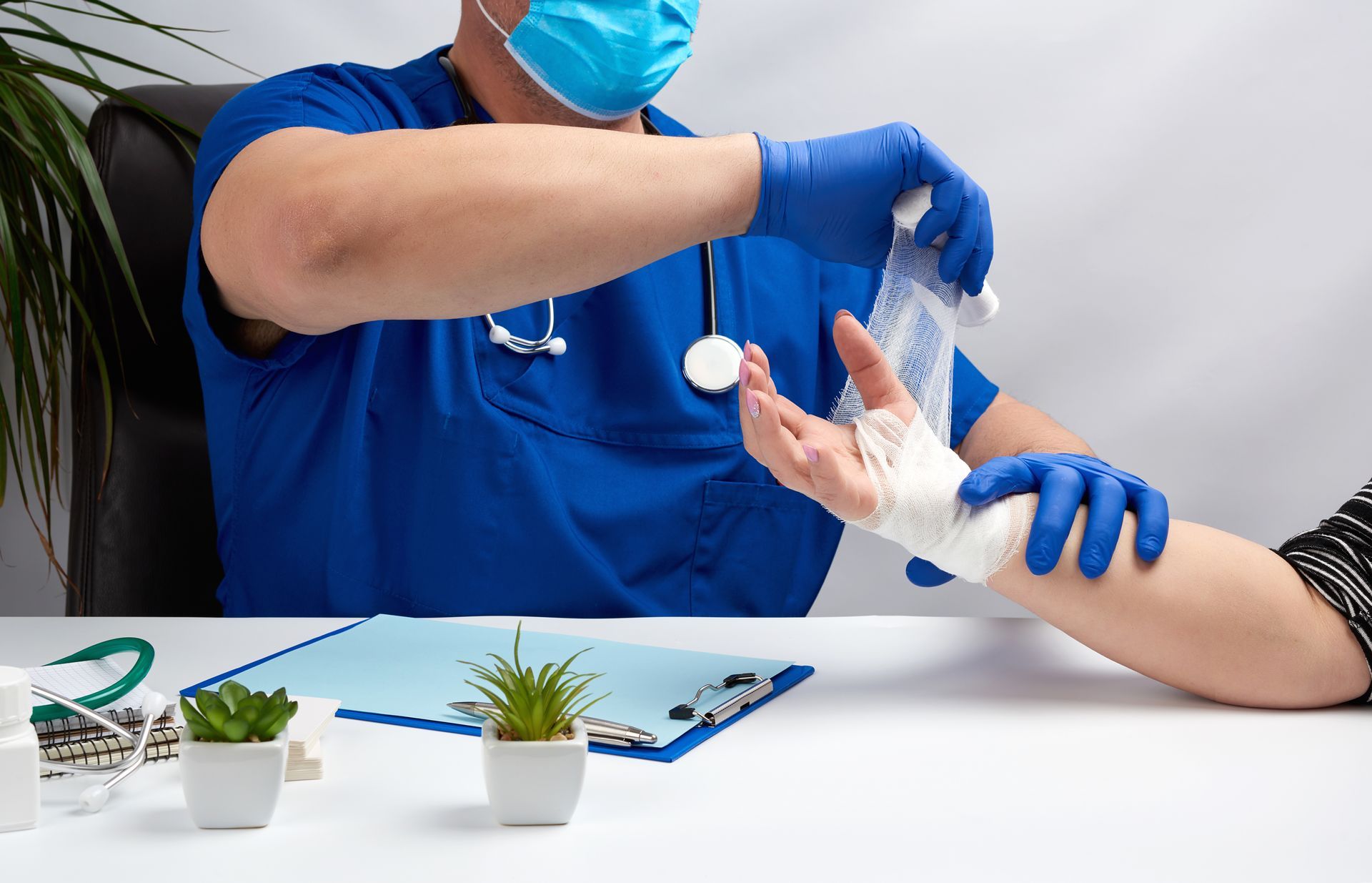 A doctor is bandaging a patient 's wrist with a bandage.