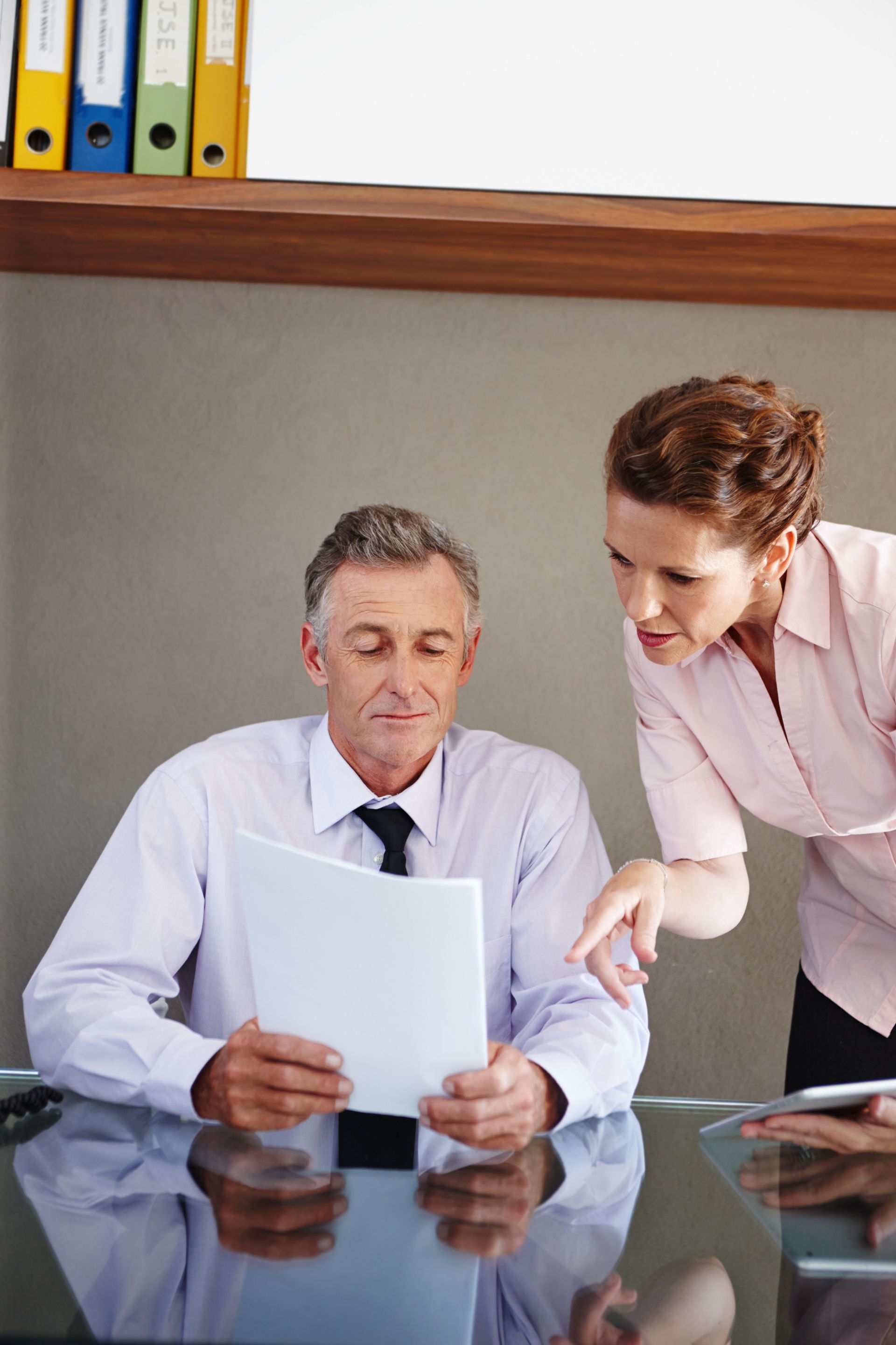 A man and a woman are looking at a piece of paper.