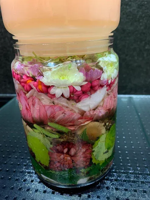 Agua de Florida. Op een tafel staat een pot gevuld met bloemen en groenten.