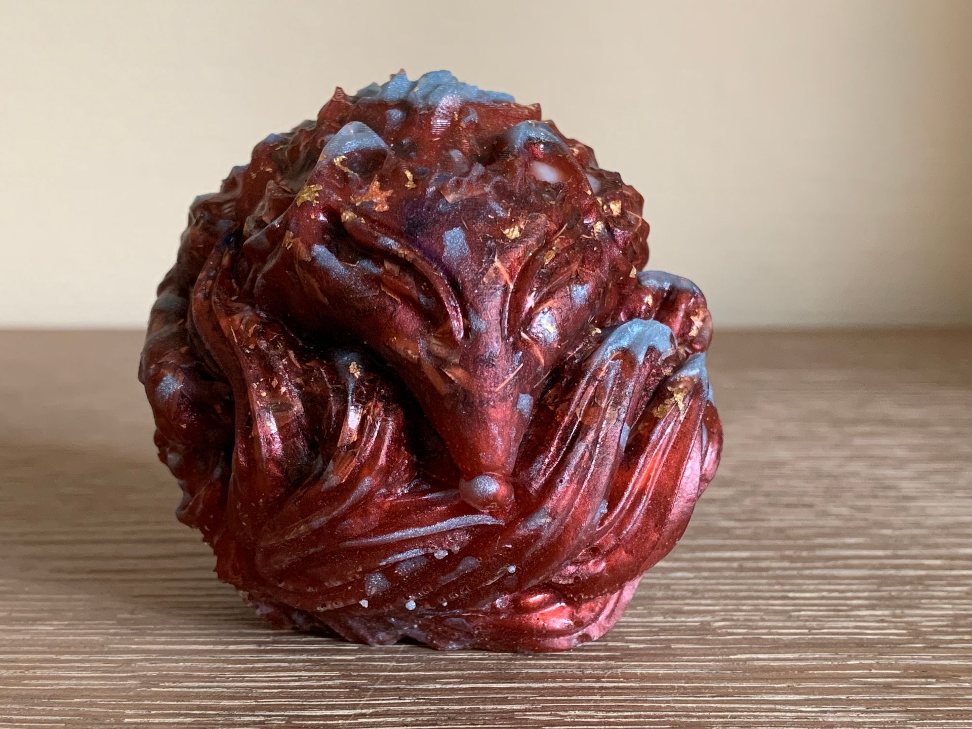 Orgonite. Een rood standbeeld van een draak op een houten tafel.