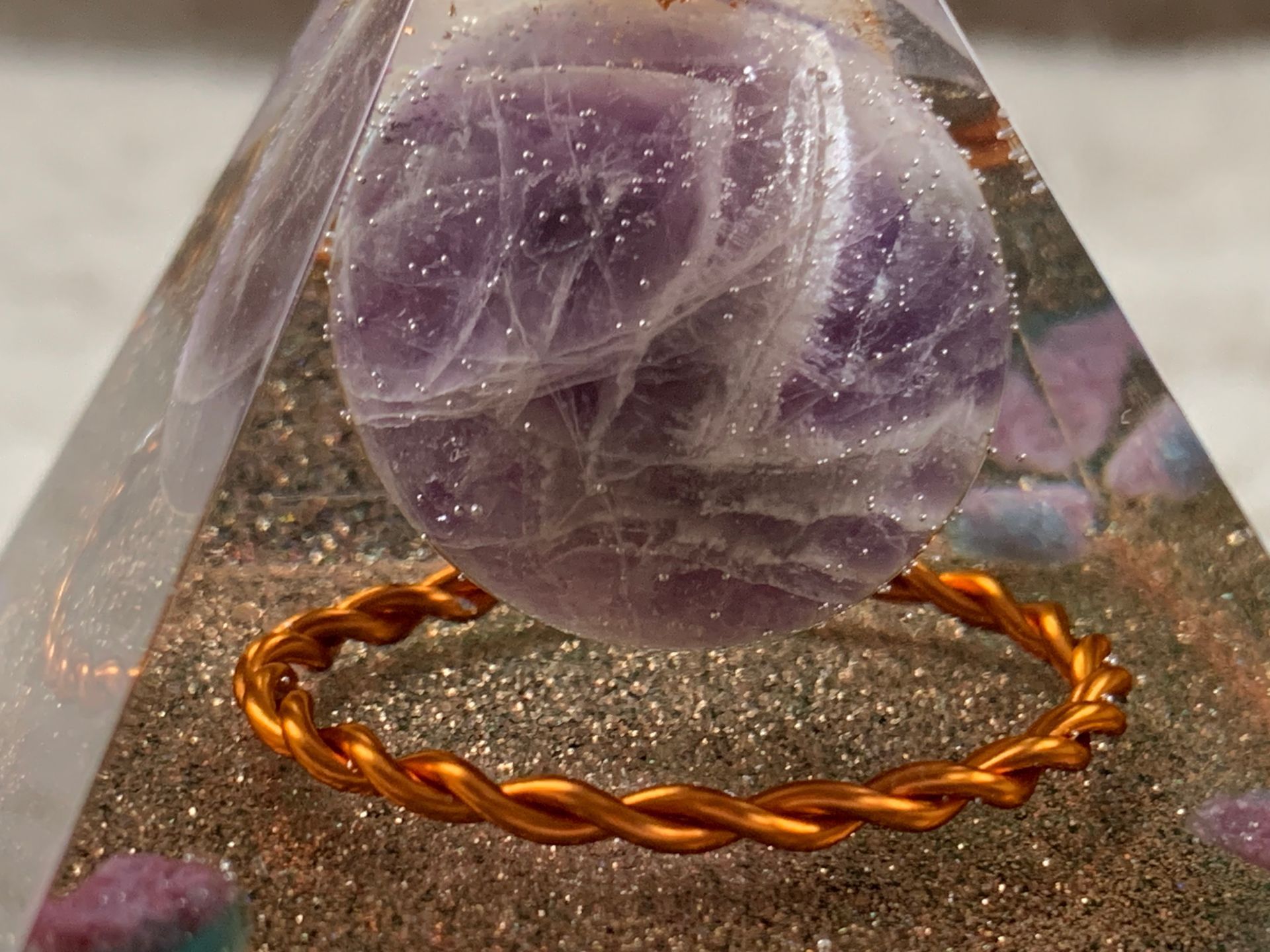 Orgonite. Een close-up van een piramide met een paarse steen erin