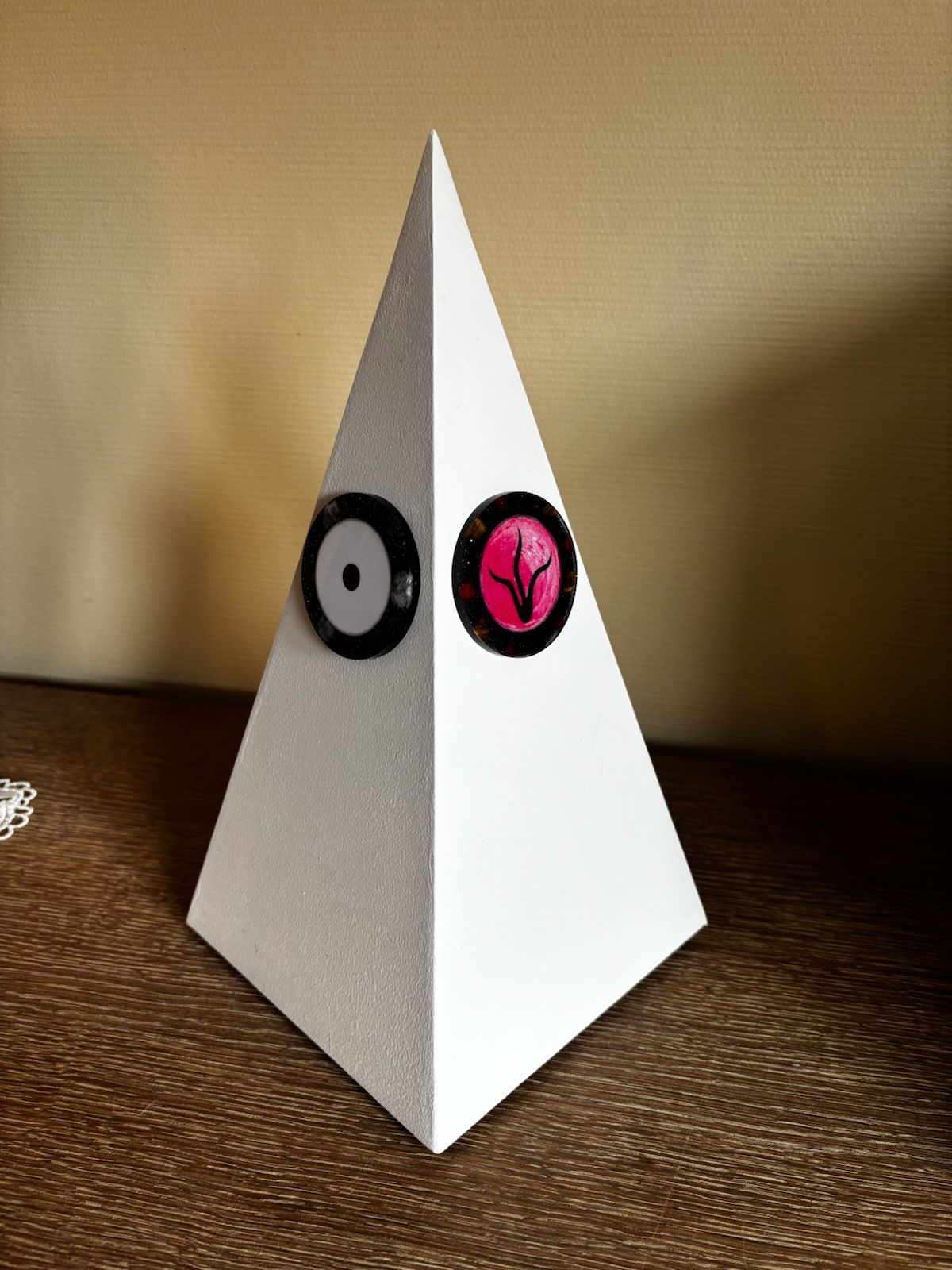 Core-piramide. Een witte piramide met twee orgonite emblemen erop