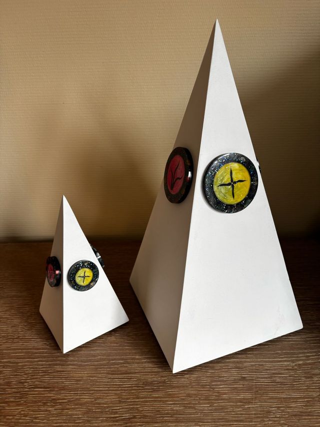 Twee witte piramides met knopen erop staan op een houten tafel.