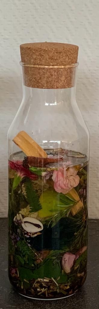 Agua de Florida. Een glazen fles met een kurken deksel gevuld met bloemen en kruiden.