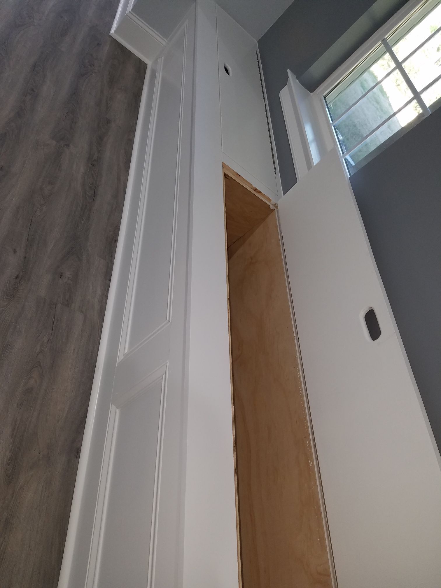 a white cabinet with a wooden shelf inside of it