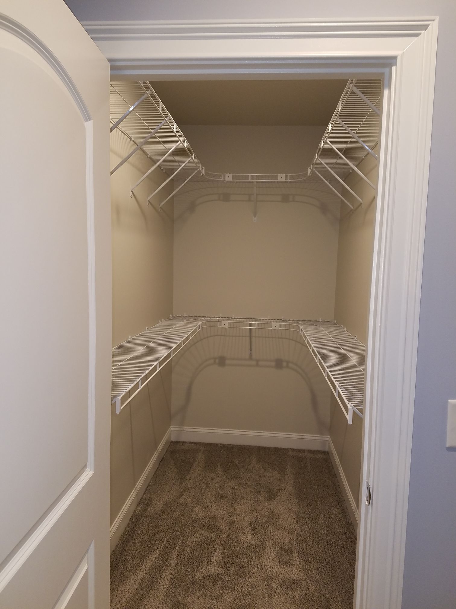 a walk in closet with shelves and a white door