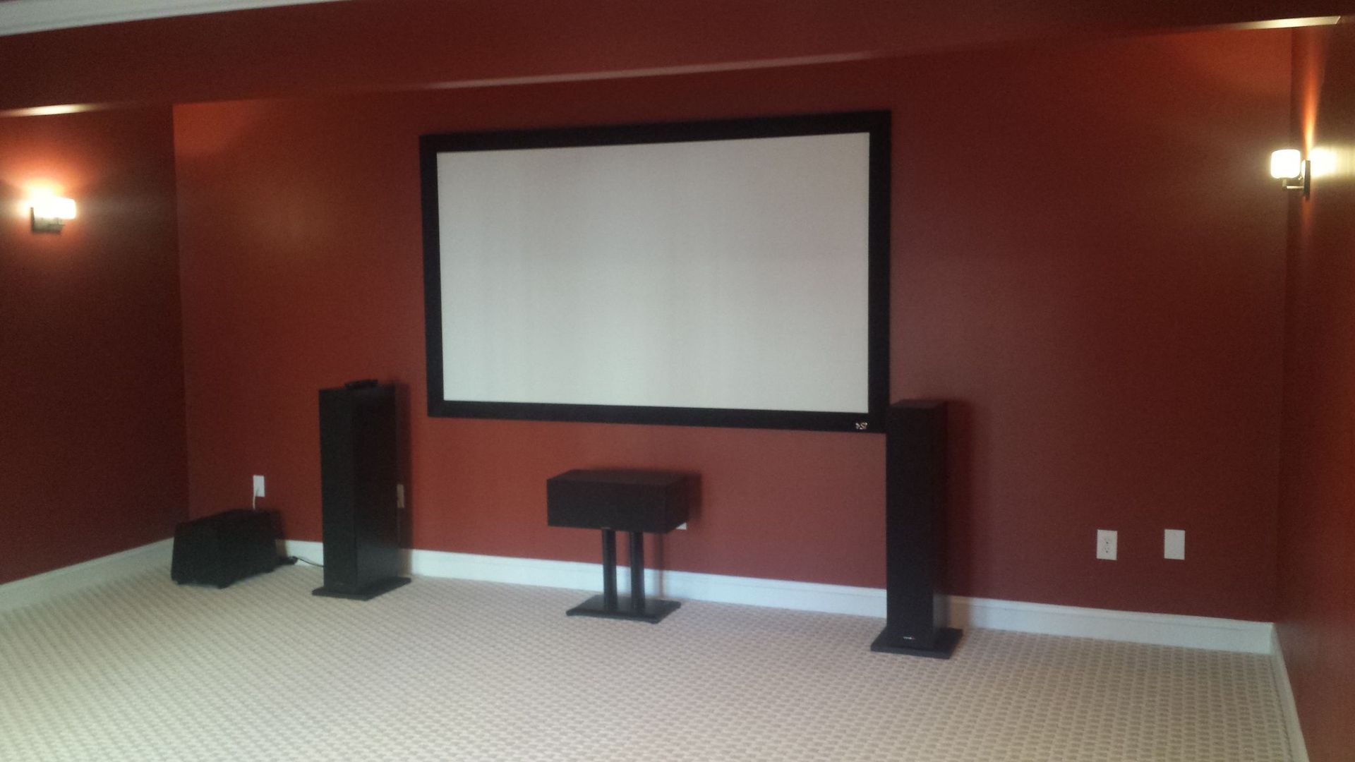 a home theater with a projector screen and speakers
