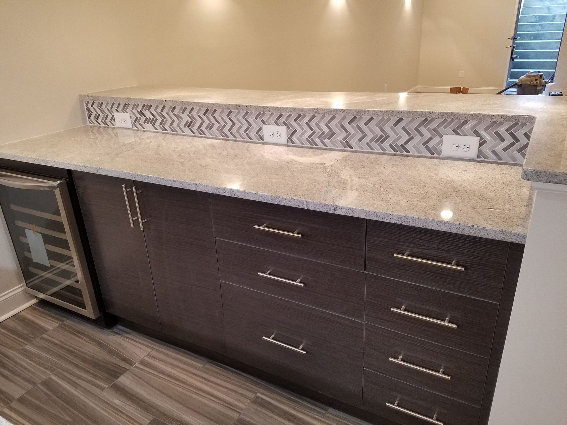 a kitchen with granite counter tops and a wine cooler