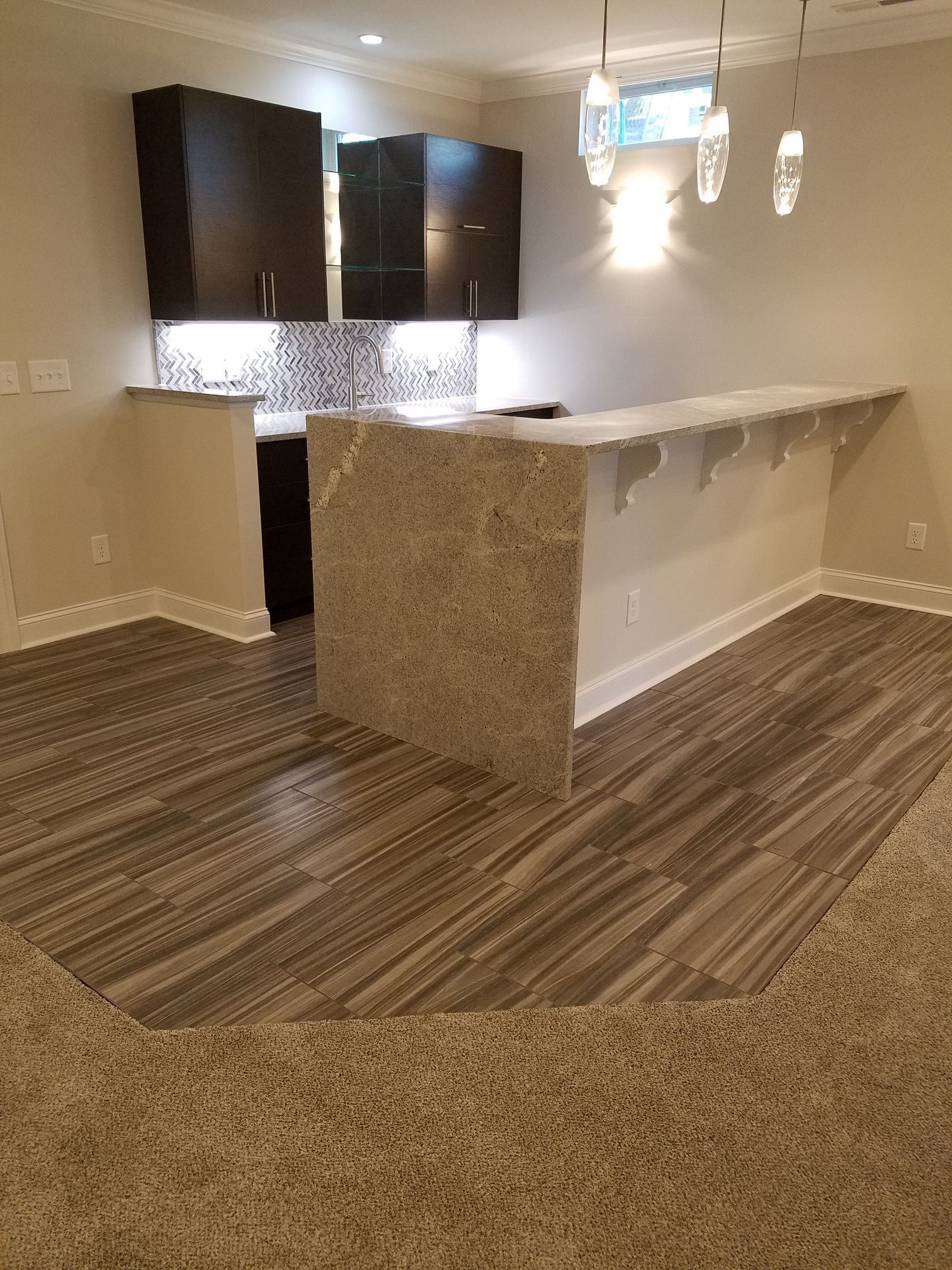 a kitchen with a marble counter top and black cabinets