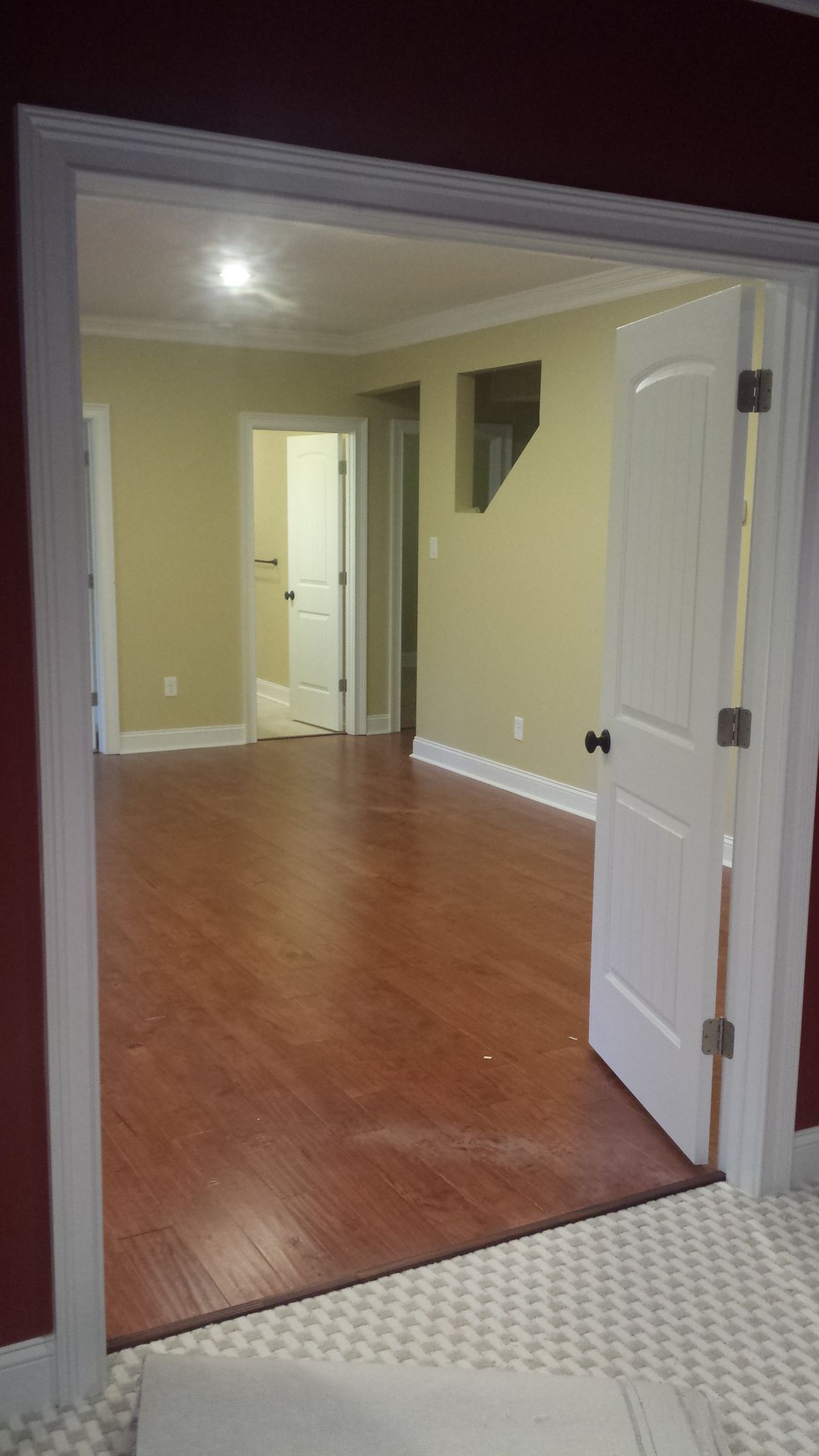 an empty room with hardwood floors and a white door