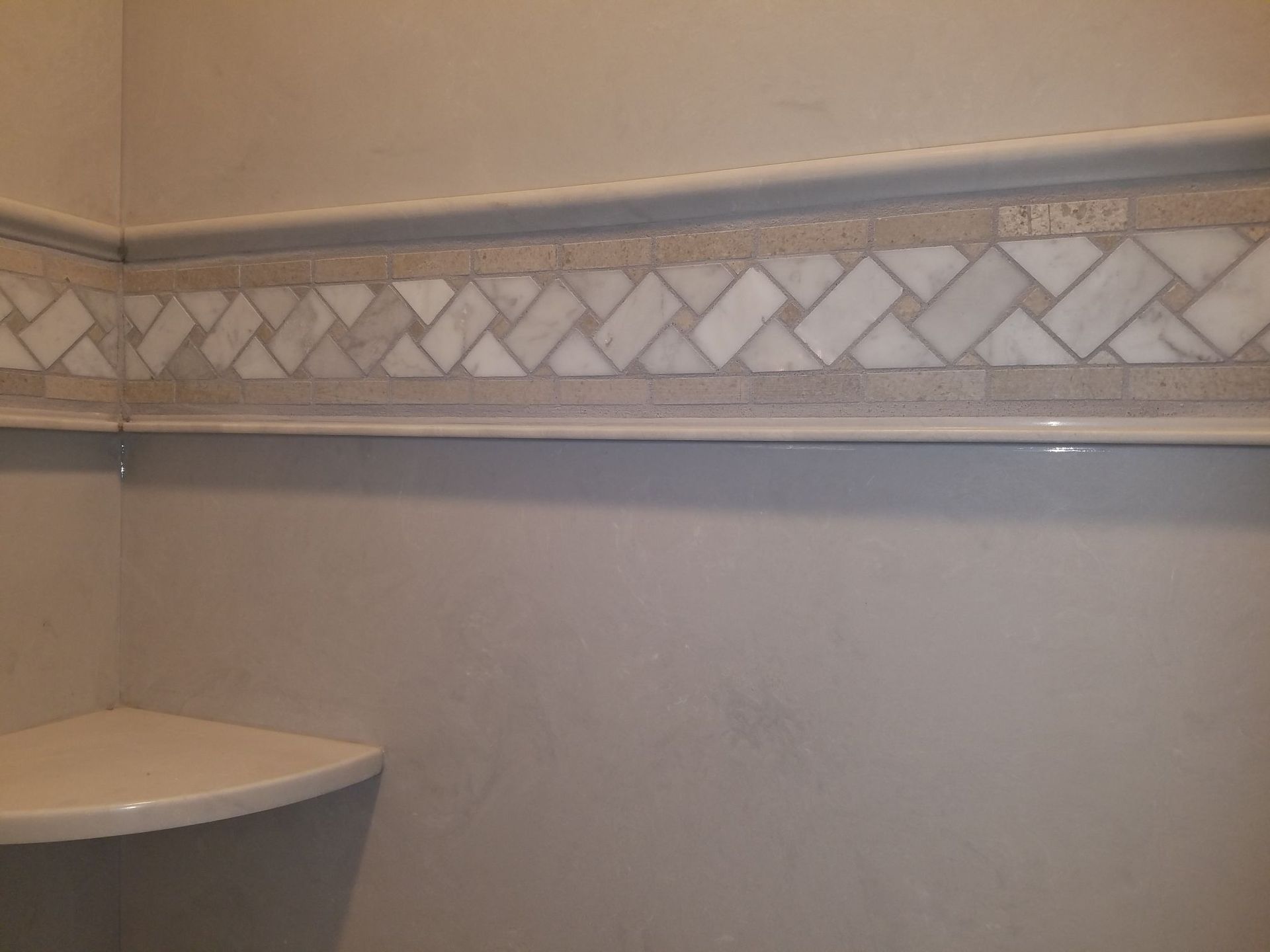 a corner of a bathroom with a marble border