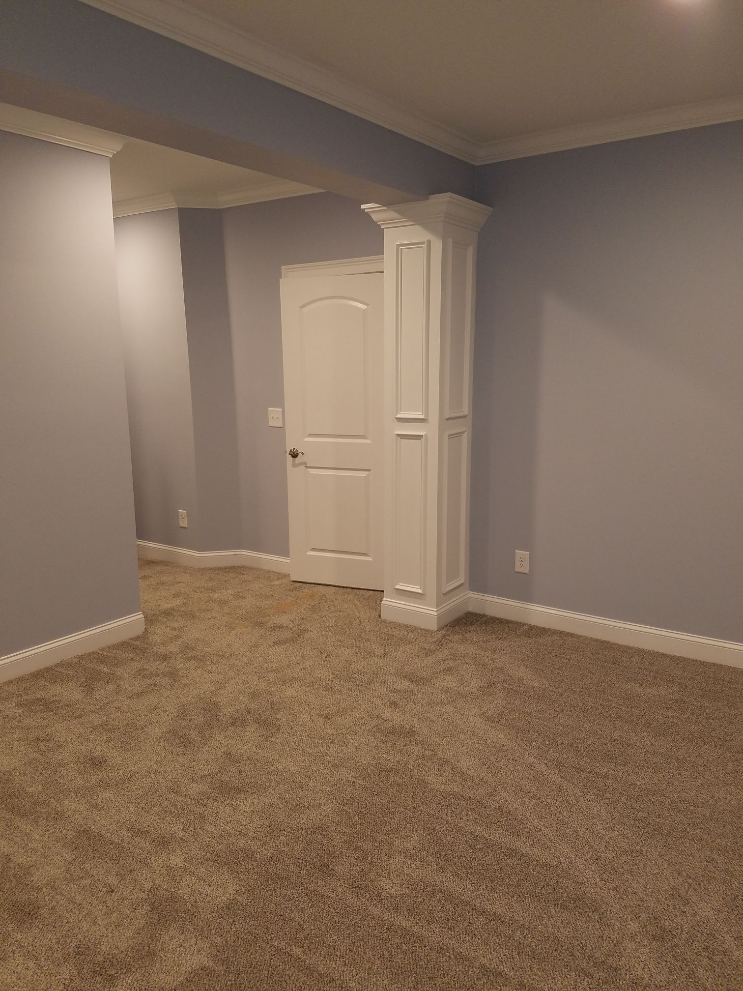 an empty room with a door and a column