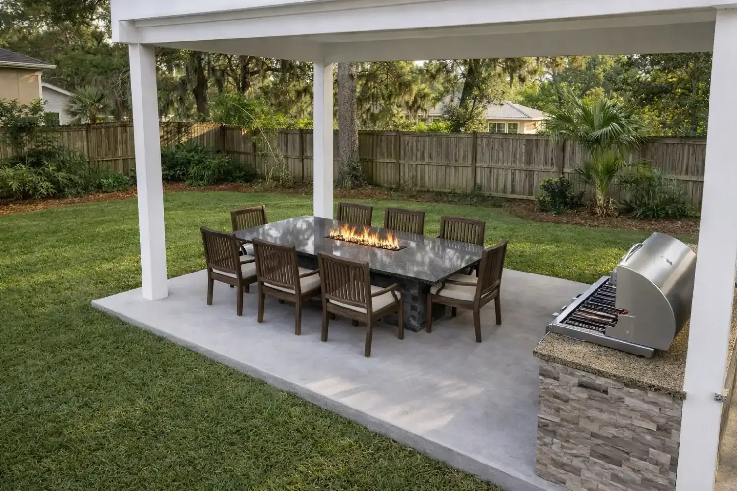 Outdoor dining area under a pergola with a fire pit table, six chairs, and a stone-clad grill station on a concrete patio.
