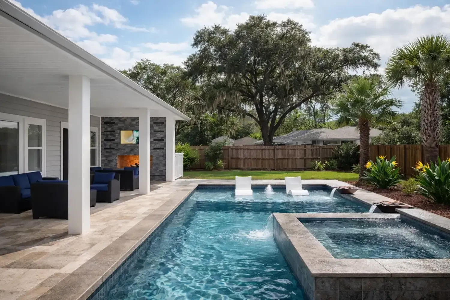 A modern backyard featuring a covered patio with outdoor seating next to a rectangular swimming pool and attached hot tub.