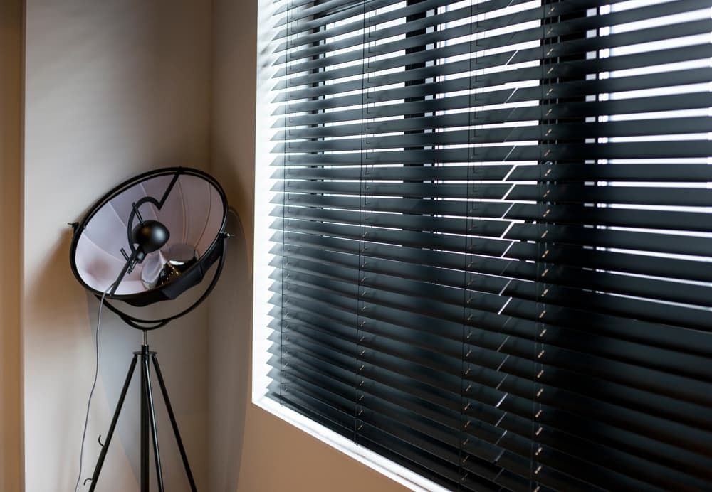 A Lamp Is Sitting Next to A Window with Black Blinds — More on the Floor in Barrack Heights, NSW