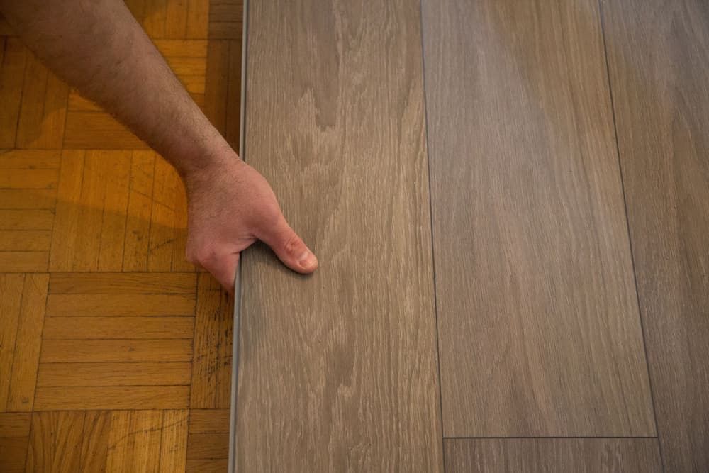 A Person Is Holding a Piece of Wood on A Wooden Floor — More on the Floor in Barrack Heights, NSW
