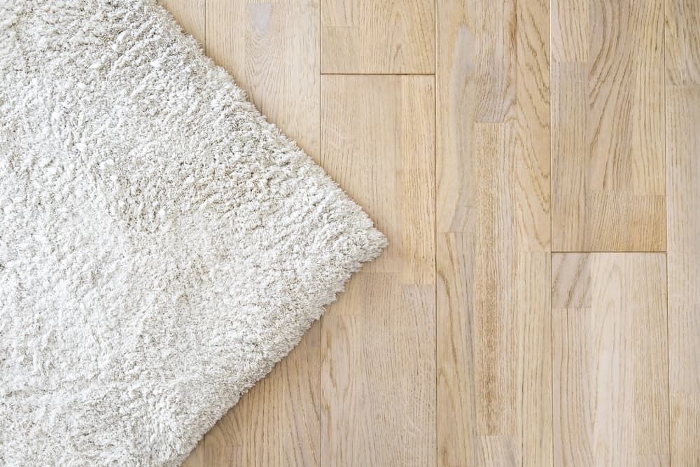 A White Rug Is Laying on A Wooden Floor — More on the Floor in Barrack Heights, NSW
