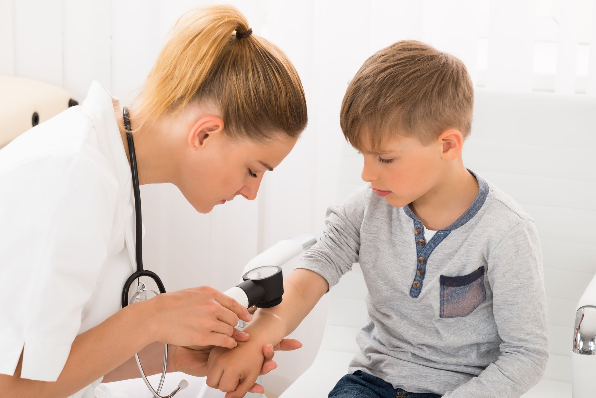 Pediatric dermatologist checking a young boy’s skin.