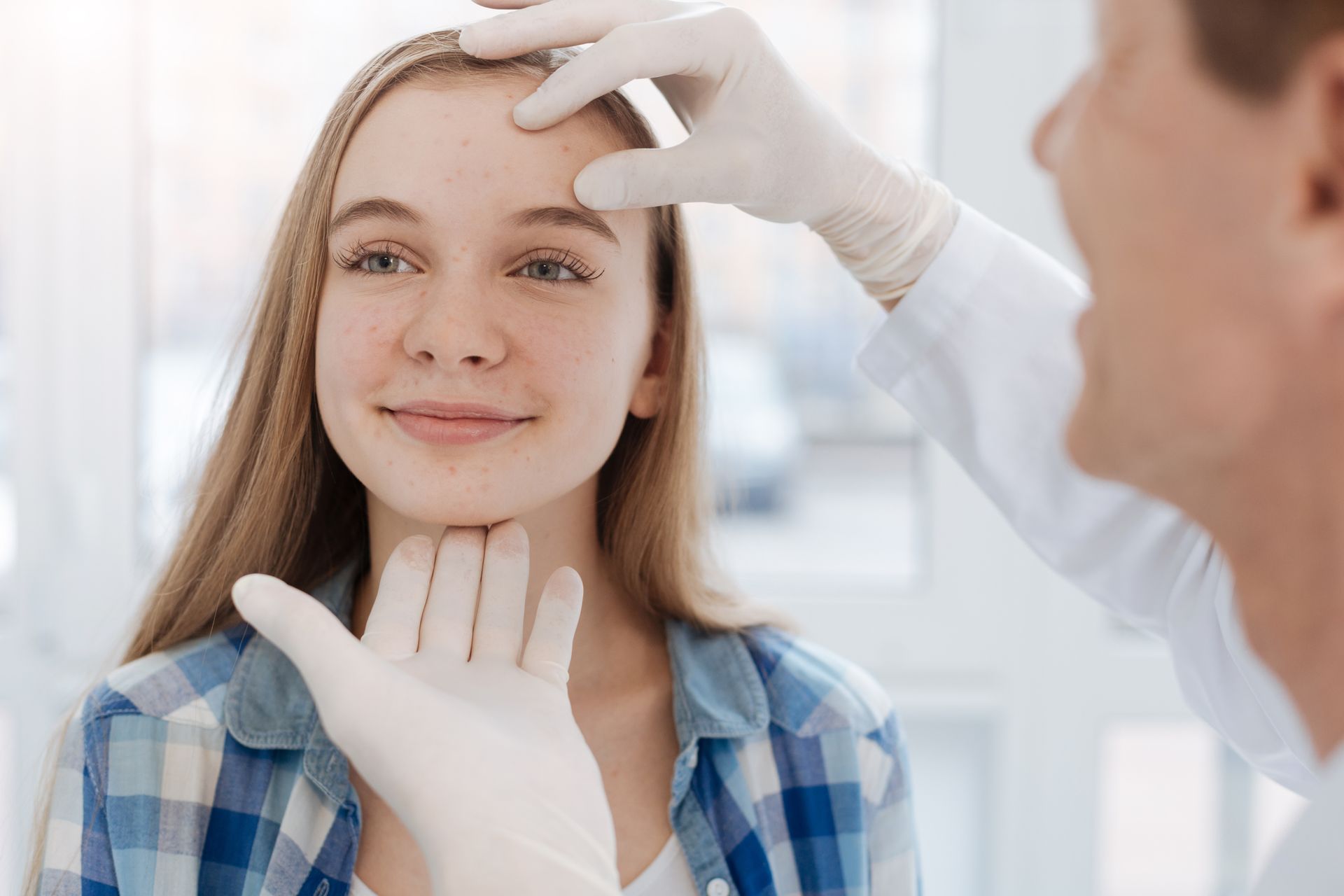 Dermatologist examining patient’s face, showcasing expert dermatology services for precise care.