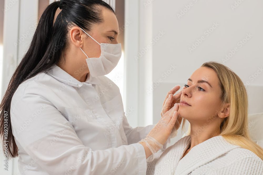 A dermatologist consults with a patient before a professional dermatology treatment.