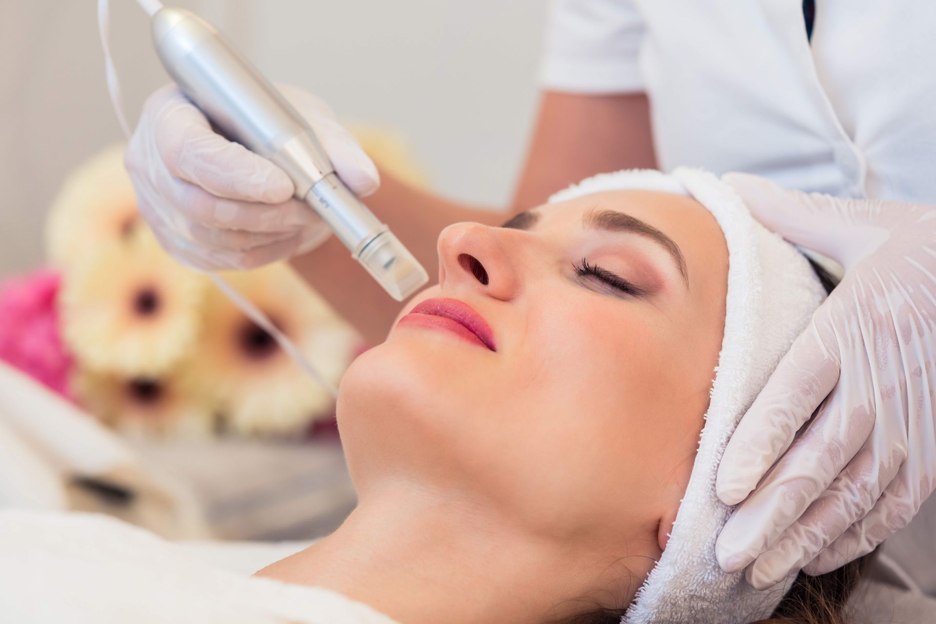 Woman enjoying a facial as part of dermatological treatment in a modern beauty center.