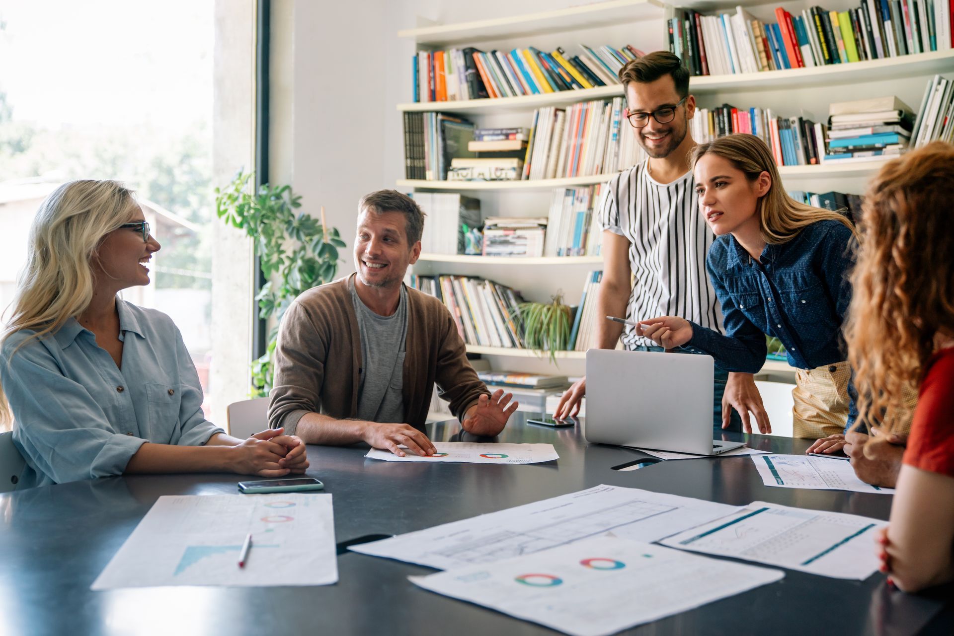 A group of people are sitting around a table having a meeting.
