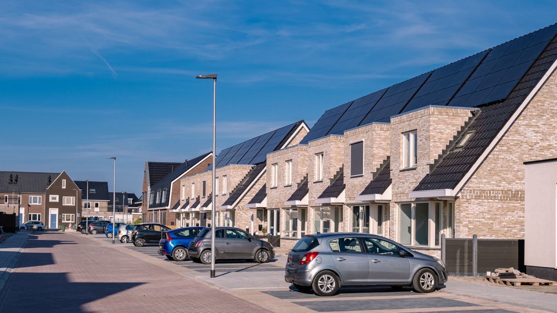 A row of houses with solar panels on the roofs.