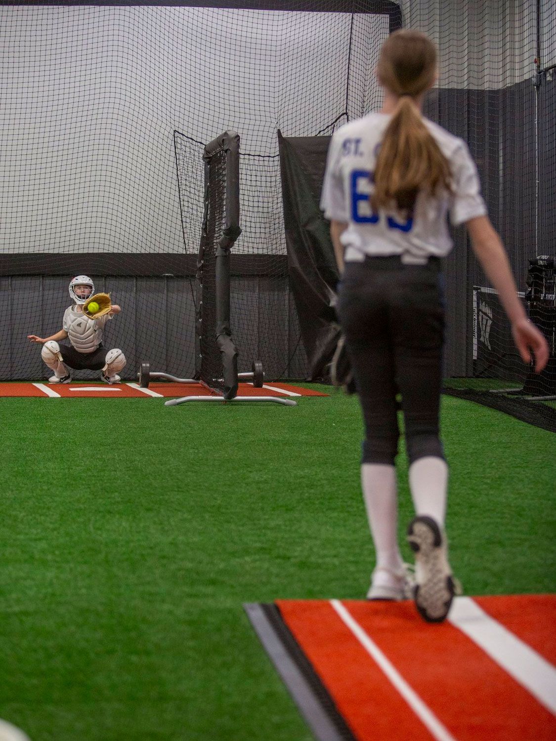 An athlete is practicing pitching at Home Turf.