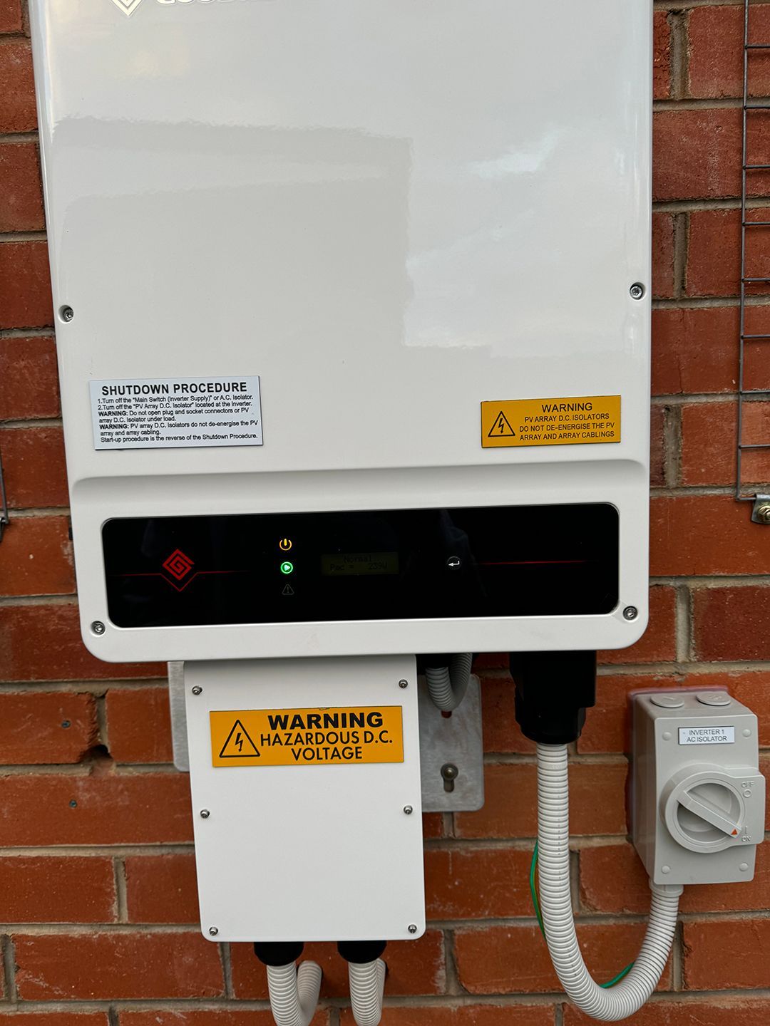 A White Box With A Warning Sign On It Is Attached To A Brick Wall — Rid-Arc Electrical In Tamworth, NSW