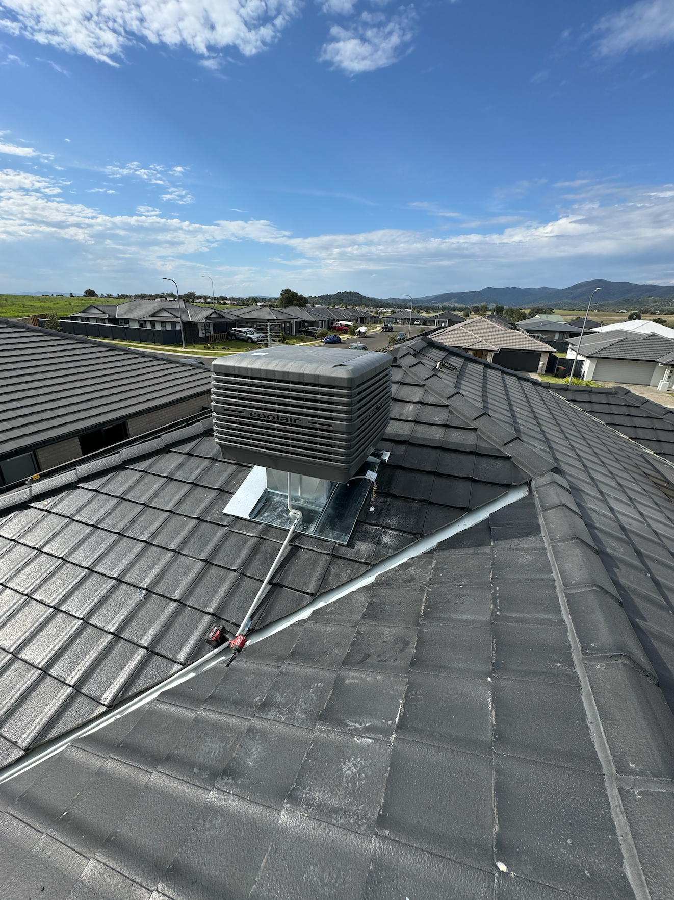 A Large Air Conditioner Is Sitting On Top Of A Roof — Rid-Arc Electrical In Tamworth, NSW