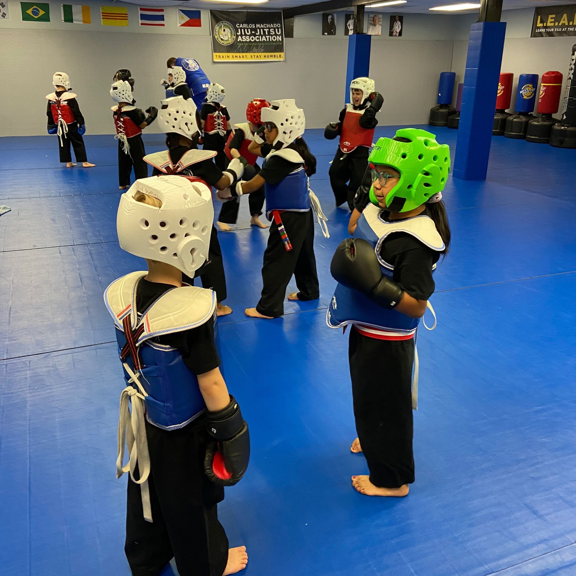 A group of kids are practicing martial arts in a gym