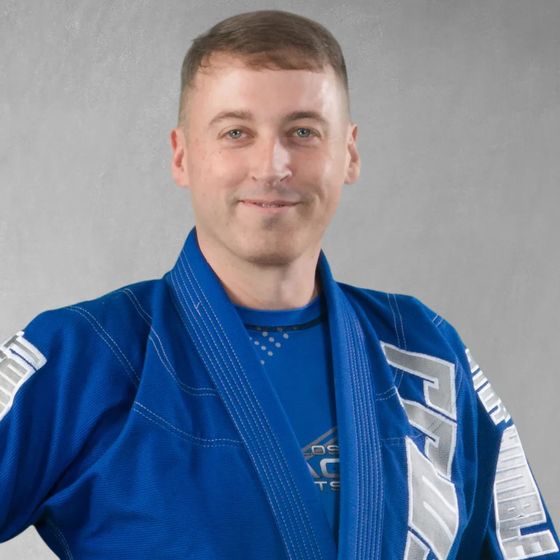 a man is wearing a blue karate uniform with the word jiu-jitsu on the sleeves