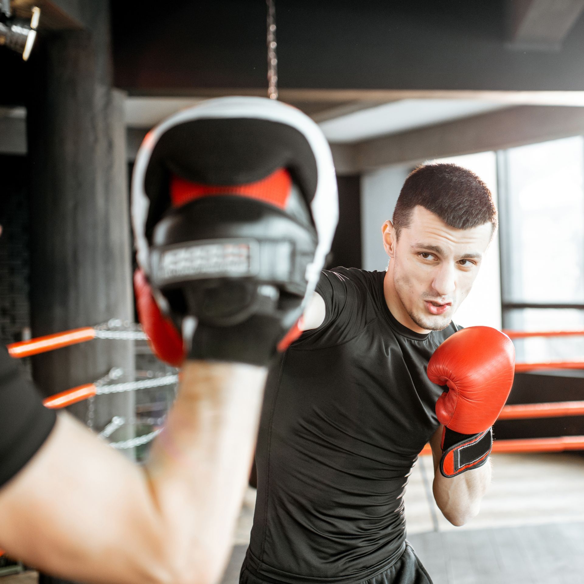 a man wearing red boxing gloves and a black shirt