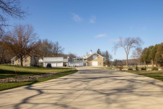 Empty suburban street with houses, bare trees, and a clear blue sky