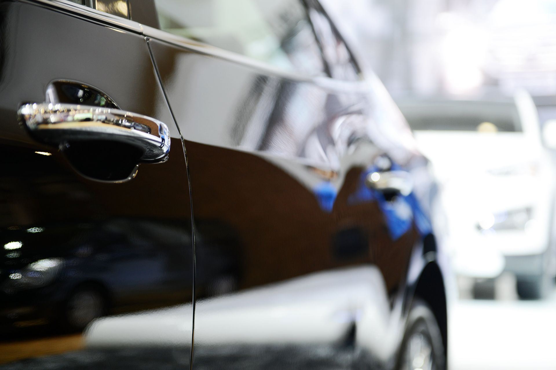 Eine Nahaufnahme des Türgriffs eines schwarzen Autos.