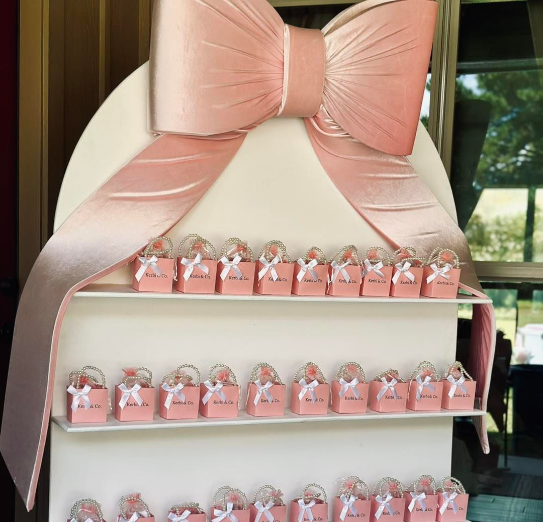 Balloon column with a welcome sign for a party. Featuring pink and cream balloons, and a sign with a Highland cow.