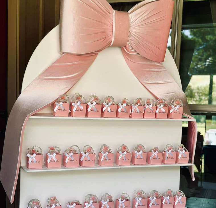 Balloon column with a welcome sign for a party. Featuring pink and cream balloons, and a sign with a Highland cow.