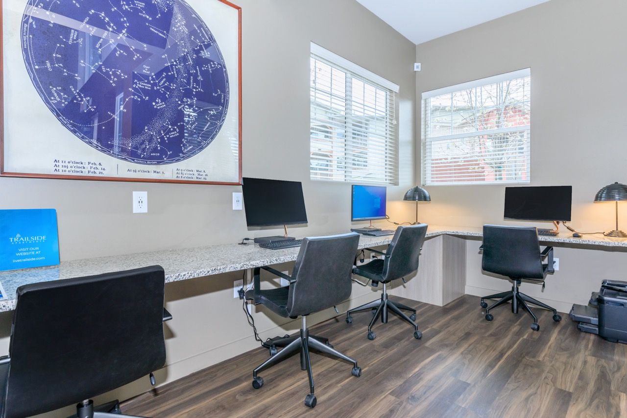 Community computer lab with desks, chairs, and multiple monitors along a granite counter.