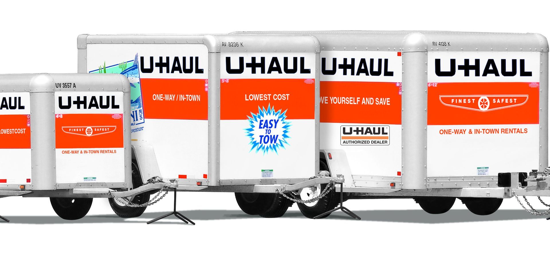 A row of u-haul moving trucks are parked next to each other on a white background.