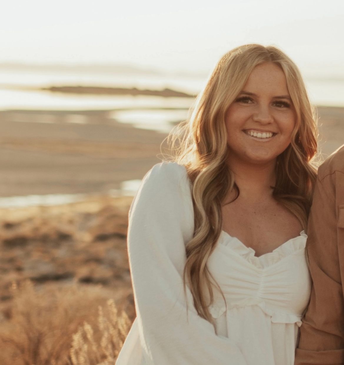 A woman in a floral shirt is smiling for the camera.