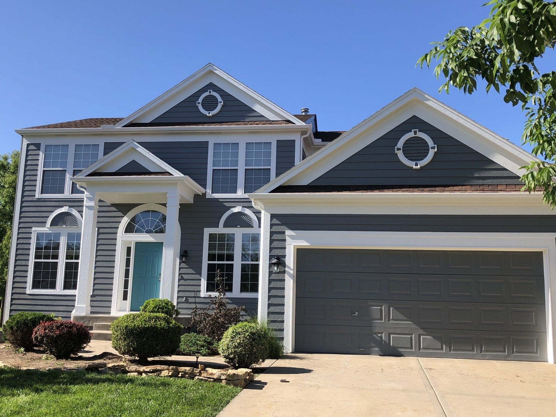 A large house with a garage and a blue door