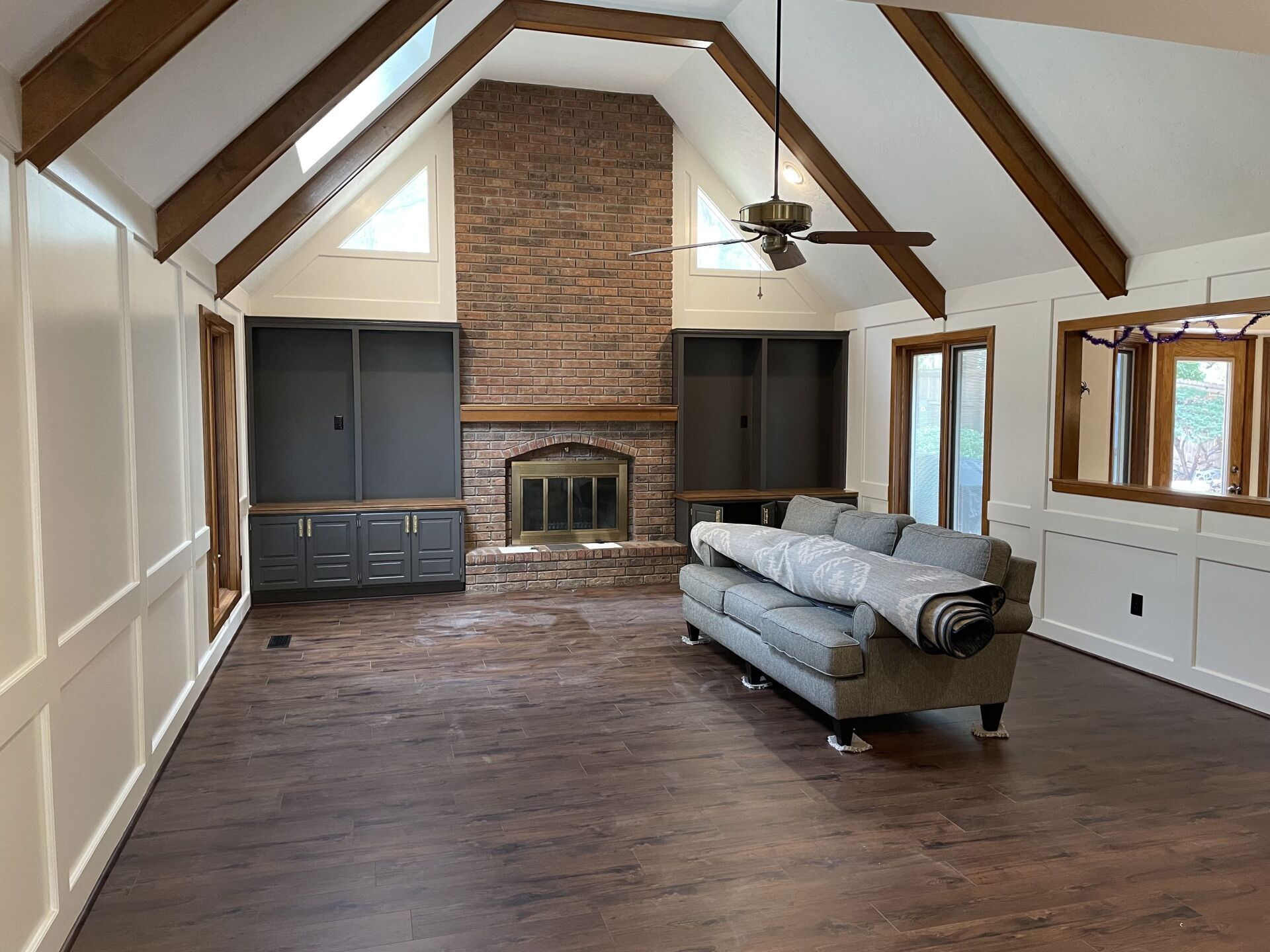 A living room with a couch , fireplace and ceiling fan.
