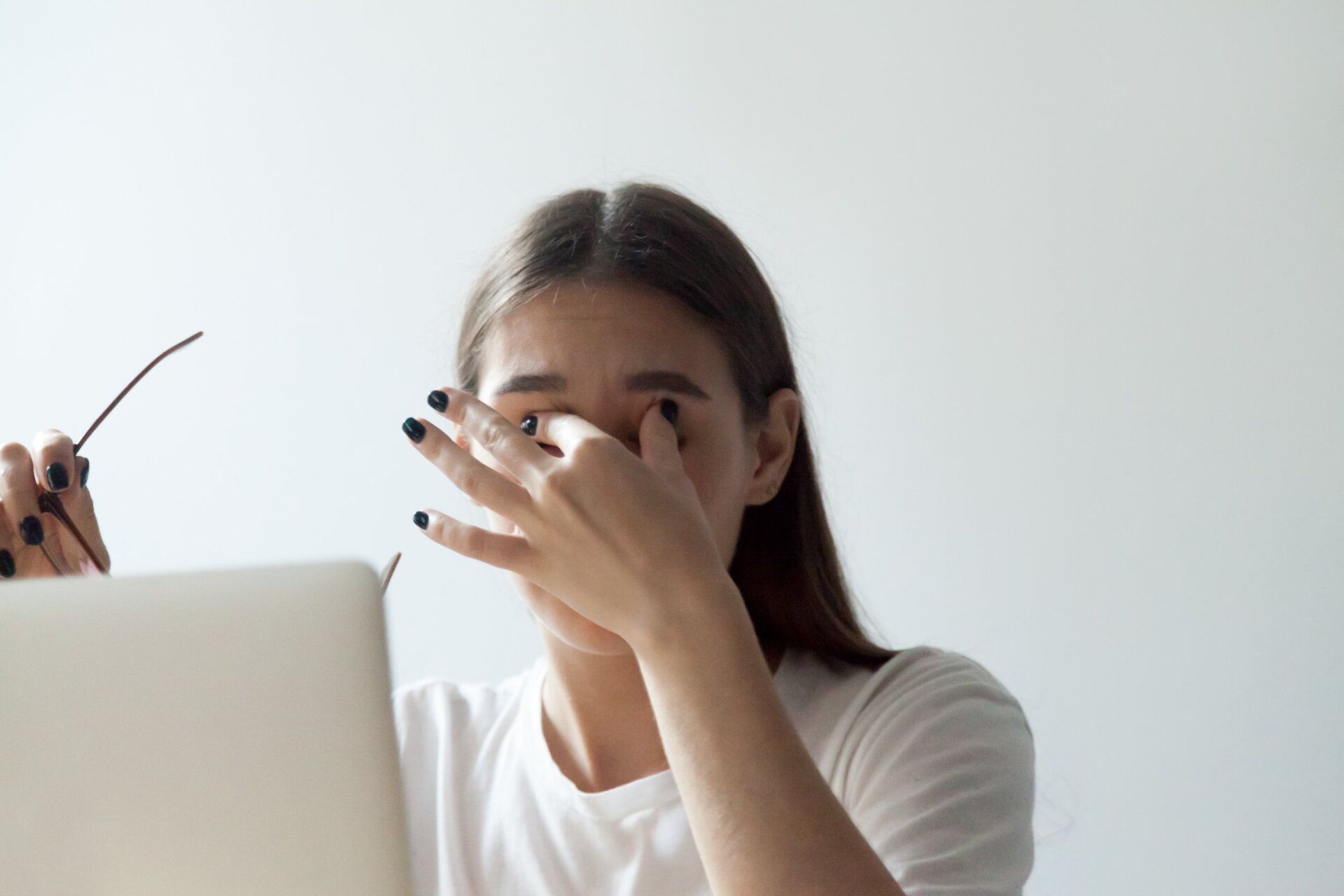 Upset female massaging eyes trying to relieve pain, suffering from head ache, distracting her from work. tired woman relaxing exhausted from too much workload. dry eyes tired from wearing spectacles