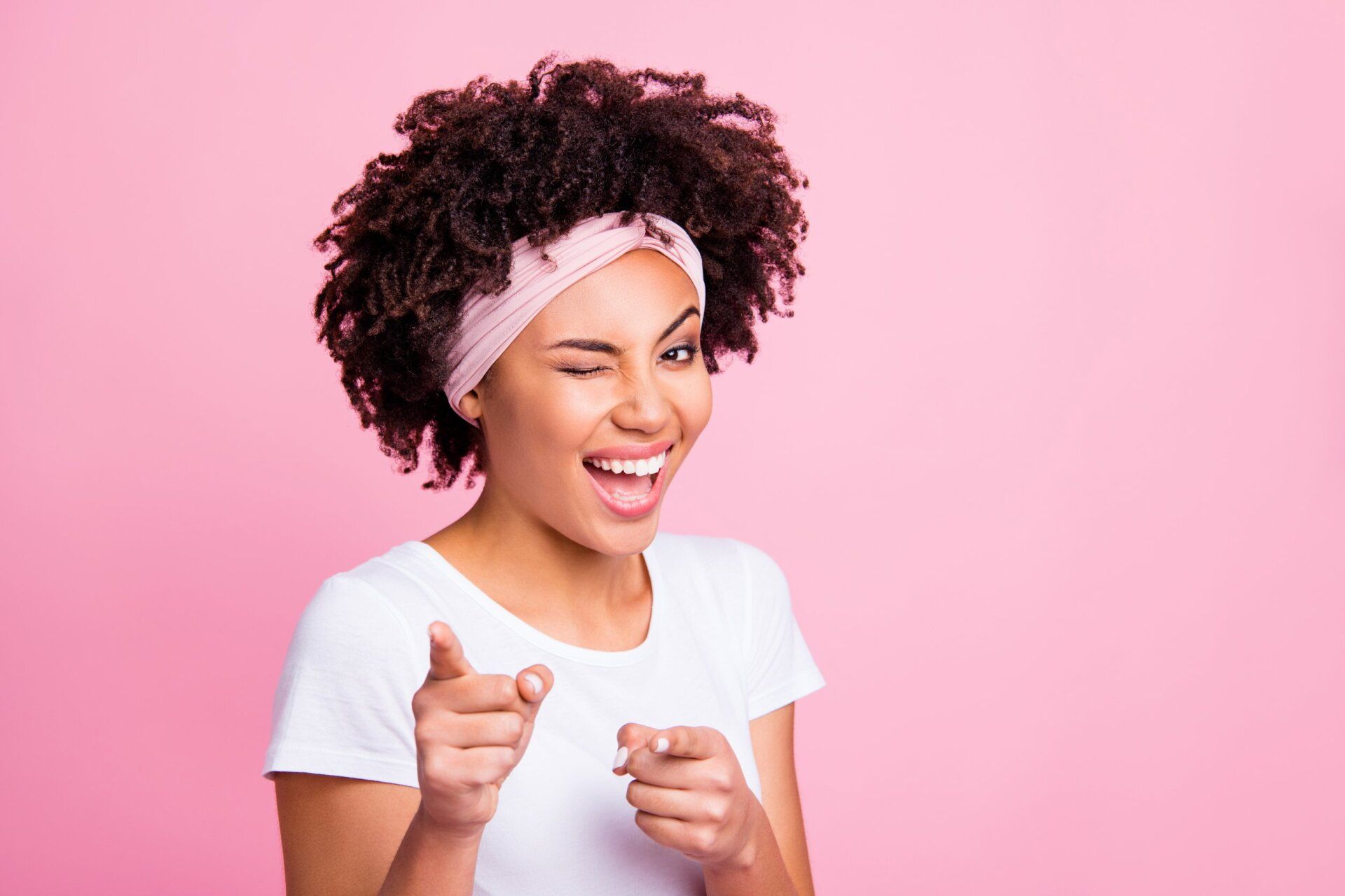 Close up photo beautiful amazing funny she her dark skin winking eyes positive friendly indicating fingers your turn its you symbol wear head scarf casual white t-shirt isolated pink bright background