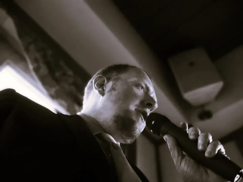 A man in a suit is singing into a microphone